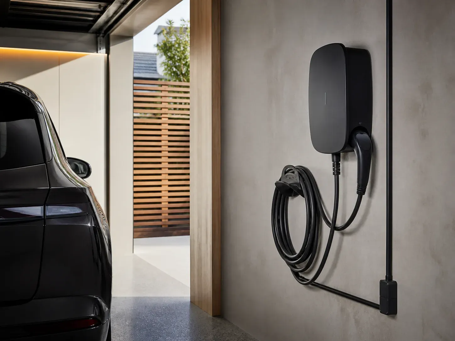 Wall-mounted home EV charger with neatly routed cable in a residential garage